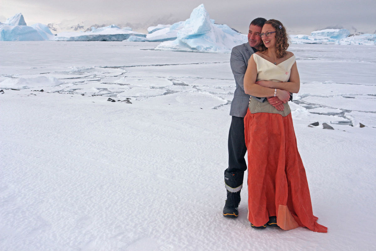 Couple holding each other after being married in Antarctica