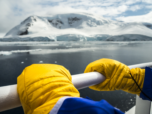 Closeup on the yellow mitts of an Antarctica-bound passenger